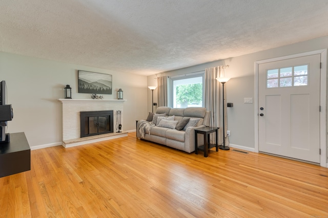 226 Farm Hill Rd, Middletown, CT 06457 - living room featuring a textured ceiling, light wood finished floors, and a brick fireplace