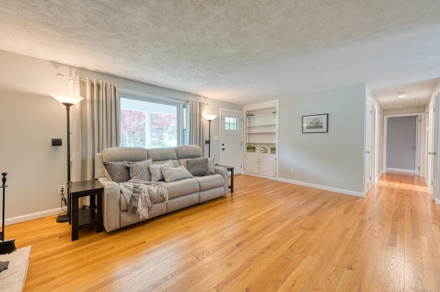 226 Farm Hill Rd, Middletown, CT 06457 - living room featuring a textured ceiling, light wood-type flooring, built in features, and attic access