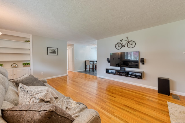 226 Farm Hill Rd, Middletown, CT 06457 - living area featuring a textured ceiling, wood finished floors, and built in shelves