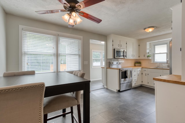 226 Farm Hill Rd, Middletown, CT 06457 - kitchen featuring stainless steel microwave, electric stove, plenty of natural light, a textured ceiling, and white cabinets