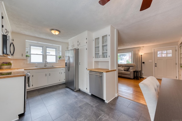 226 Farm Hill Rd, Middletown, CT 06457 - kitchen with appliances with stainless steel finishes, a ceiling fan, plenty of natural light, white cabinetry, and a textured ceiling