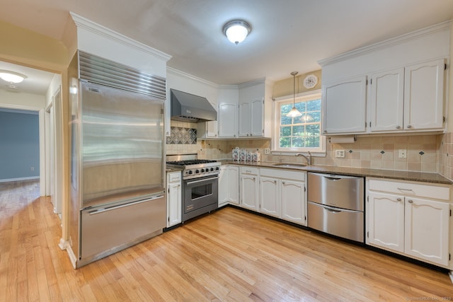 20 Copper Hill Dr Unit 20, Guilford, CT 06437 - kitchen featuring high end appliances, wall chimney range hood, light wood-type flooring, white cabinetry, and crown molding