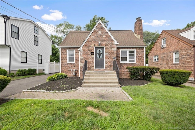 30 Cedar Crest Pl, Norwalk, CT 06854 - view of front facade with brick siding, a front lawn, a chimney, and roof with shingles