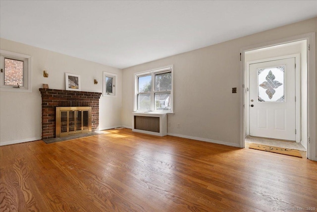 30 Cedar Crest Pl, Norwalk, CT 06854 - unfurnished living room with radiator heating unit, a fireplace, and wood finished floors