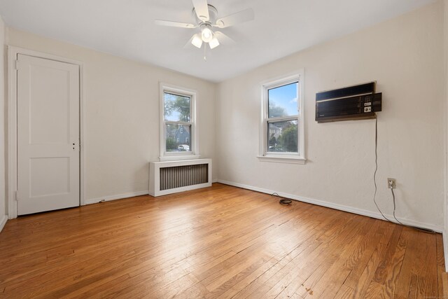 30 Cedar Crest Pl, Norwalk, CT 06854 - unfurnished room with radiator, a wall unit AC, light wood-type flooring, and plenty of natural light