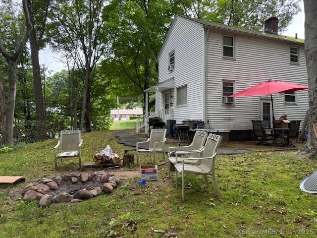 131 N Ridgeland Rd, Wallingford, CT 06492 - back of house featuring a chimney, cooling unit, a patio, and a lawn