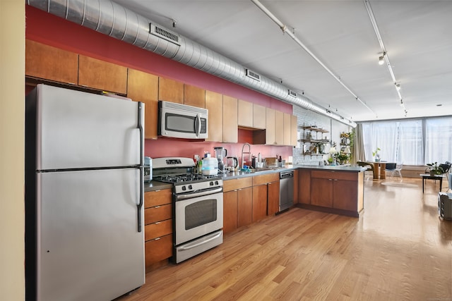 817 Grand Ave Unit 202, New Haven, CT 06511 - kitchen with stainless steel appliances, track lighting, light wood-style floors, brown cabinetry, and a peninsula
