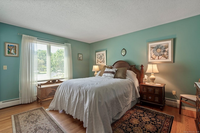 bedroom featuring a textured ceiling, wood finished floors, and a baseboard radiator