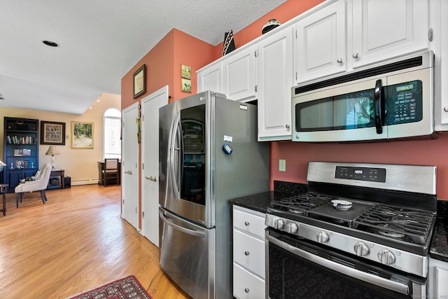 kitchen with appliances with stainless steel finishes, white cabinets, light wood-type flooring, a baseboard radiator, and open floor plan