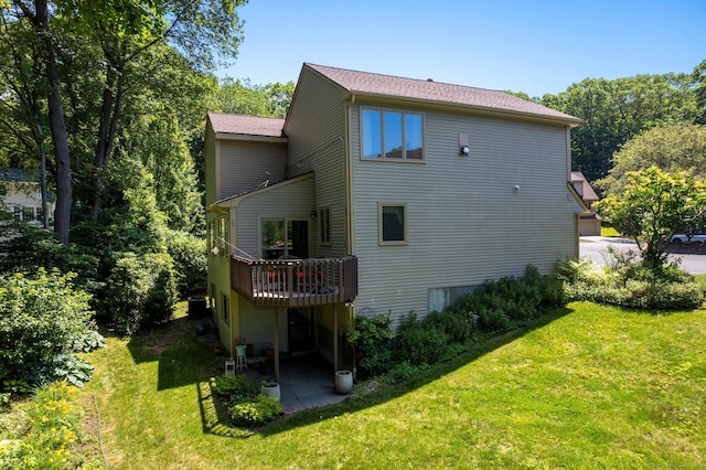 back of property with a yard, a patio area, and a deck