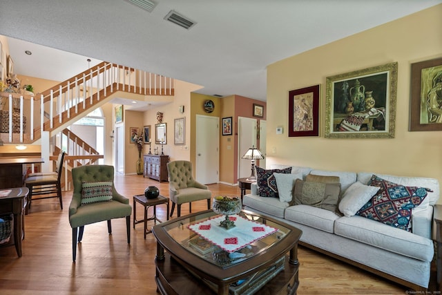 living area with stairway and wood finished floors
