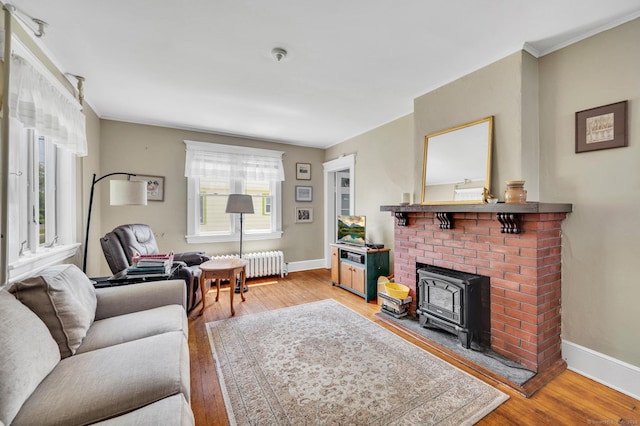 159 Jefferson St, Stratford, CT 06615 - living room featuring radiator, light wood-type flooring, a wood stove, and crown molding