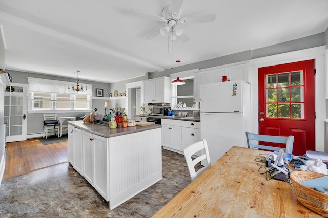 159 Jefferson St, Stratford, CT 06615 - kitchen featuring freestanding refrigerator, stainless steel microwave, white cabinetry, a kitchen island, and pendant lighting
