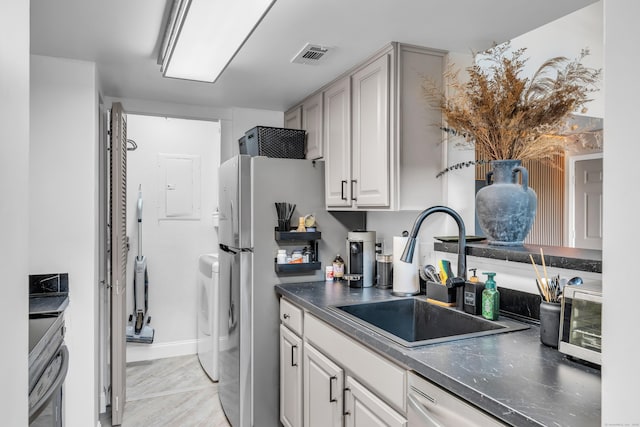 323 Carriage Crossing Ln Unit 323, Middletown, CT 06457 - kitchen featuring stainless steel appliances, washer / dryer, dark countertops, and white cabinets