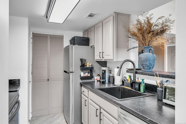 323 Carriage Crossing Ln Unit 323, Middletown, CT 06457 - kitchen with range, dark countertops, dishwashing machine, freestanding refrigerator, and light wood-type flooring