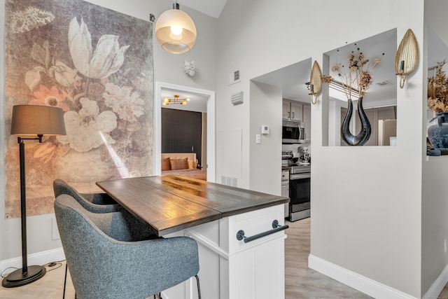 323 Carriage Crossing Ln Unit 323, Middletown, CT 06457 - kitchen with appliances with stainless steel finishes, dark countertops, a high ceiling, and white cabinetry