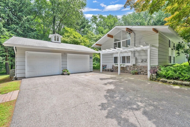 12 Twin Ponds Dr, Farmington, CT 06085 - view of front of property featuring a pergola, an outdoor structure, a detached garage, and view of wooded area