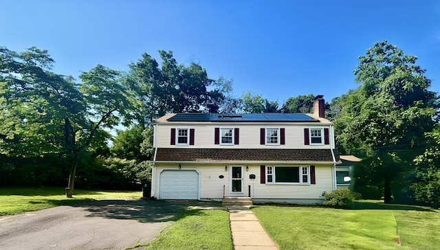36 Westmoreland Dr, West Hartford, CT 06117 - view of front of property with a chimney, solar panels, driveway, a front yard, and an attached garage