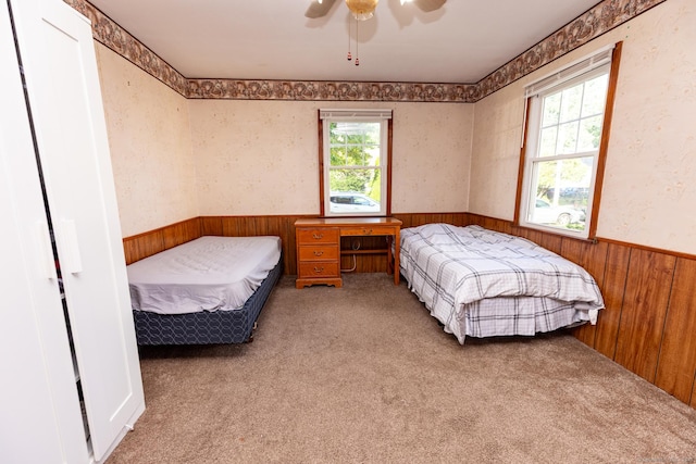 302 E Pasadena Pl, Bridgeport, CT 06610 - carpeted bedroom with a wainscoted wall, wooden walls, and ceiling fan