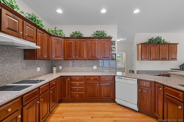 92 Tyler City Rd, Orange, CT 06477 - kitchen featuring white dishwasher, black electric cooktop, under cabinet range hood, light wood-style floors, and decorative backsplash