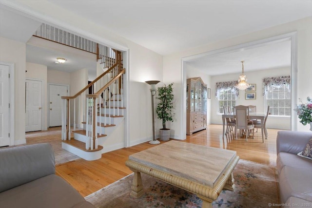 92 Tyler City Rd, Orange, CT 06477 - living room with wood finished floors, a chandelier, and stairway