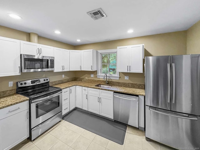 7 Ambler Rd W, Westport, CT 06880 - kitchen with stainless steel appliances, white cabinetry, light stone countertops, recessed lighting, and light tile patterned floors