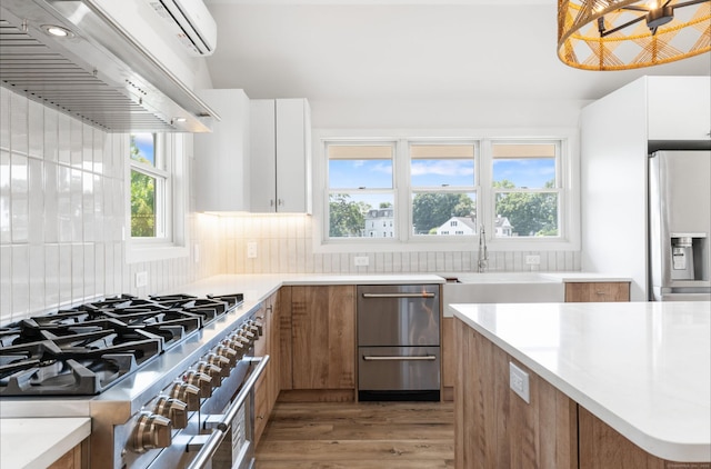 281 E Ave, Norwalk, CT 06850 - kitchen featuring modern cabinets, stainless steel appliances, exhaust hood, light wood-style flooring, and light countertops