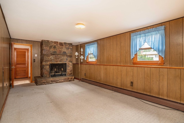 102 Herbert Dr, East Hartford, CT 06118 - unfurnished living room with baseboard heating, healthy amount of natural light, wood walls, a stone fireplace, and carpet floors