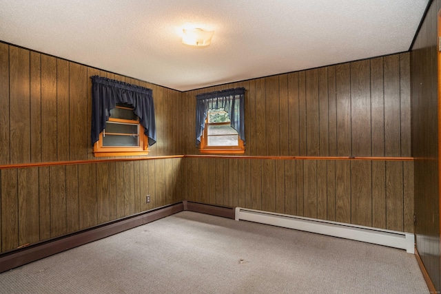 102 Herbert Dr, East Hartford, CT 06118 - empty room featuring carpet floors, wood walls, a baseboard radiator, and a textured ceiling
