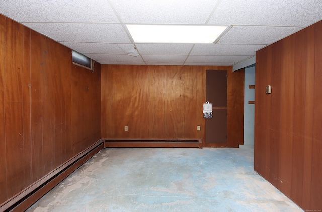 109 Pinnacle Rd, Ellington, CT 06029 - unfurnished room featuring baseboard heating, wood walls, unfinished concrete flooring, and a drop ceiling