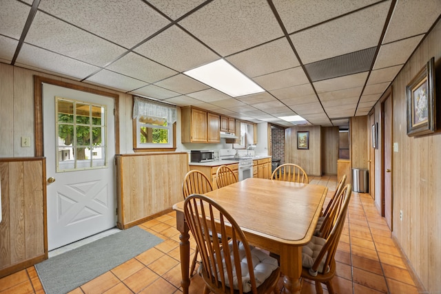 95 Flagg Ave, Watertown, CT 06779 - dining space with wood walls, light tile patterned floors, and a drop ceiling