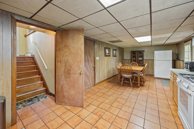 95 Flagg Ave, Watertown, CT 06779 - dining room with light tile patterned floors, stairs, a drop ceiling, and wood walls