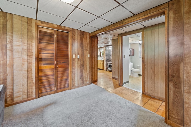 95 Flagg Ave, Watertown, CT 06779 - unfurnished bedroom featuring wooden walls, tile patterned floors, a closet, a paneled ceiling, and carpet floors