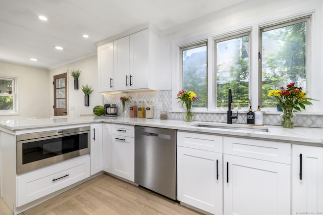 207 Hillcrest Rd, Bridgeport, CT 06606 - kitchen with stainless steel dishwasher, light stone countertops, ornamental molding, a peninsula, and backsplash