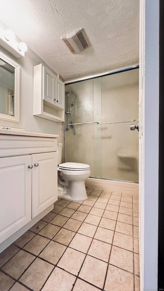 55 Thompson St Unit 17H, East Haven, CT 06513 - bathroom with vanity, a textured ceiling, a stall shower, and tile patterned floors
