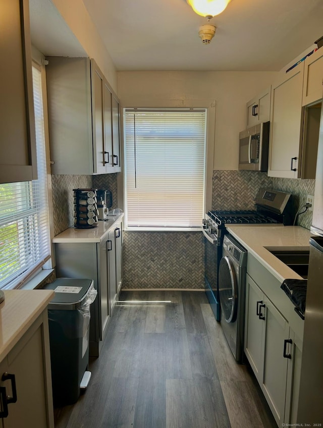 744 Canaan Rd Unit 23, Bridgeport, CT 06610 - kitchen with stainless steel appliances, washer / clothes dryer, light countertops, dark wood-style flooring, and backsplash
