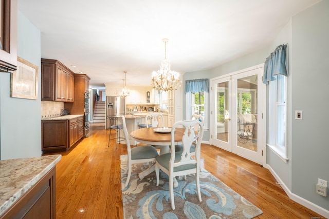 51 Wood Lot Ln, Southbury, CT 06488 - dining space featuring a chandelier, light wood-style flooring, french doors, and stairway