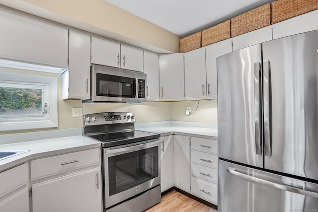69 Ellsworth St Apt 101, Bridgeport, CT 06605 - kitchen featuring appliances with stainless steel finishes, light countertops, white cabinets, and light wood finished floors