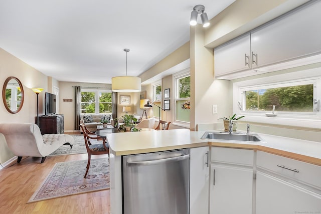 69 Ellsworth St Apt 101, Bridgeport, CT 06605 - kitchen featuring stainless steel dishwasher, open floor plan, light countertops, light wood-type flooring, and a peninsula