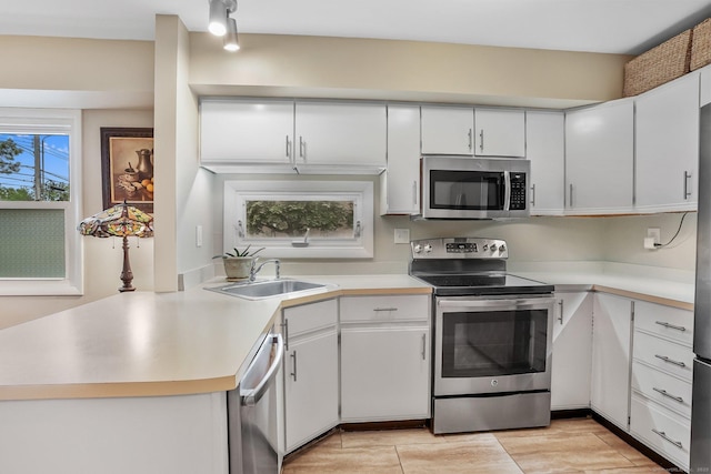 69 Ellsworth St Apt 101, Bridgeport, CT 06605 - kitchen with appliances with stainless steel finishes, light countertops, white cabinetry, and a peninsula