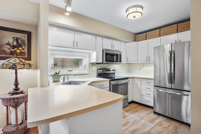 69 Ellsworth St Apt 101, Bridgeport, CT 06605 - kitchen with stainless steel appliances, a peninsula, light countertops, and white cabinetry
