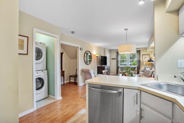 69 Ellsworth St Apt 101, Bridgeport, CT 06605 - kitchen featuring dishwasher, stacked washer / dryer, light countertops, light wood finished floors, and decorative light fixtures