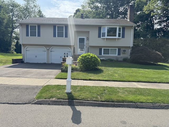 352 Knob Hill Dr, Hamden, CT 06518 - split foyer home with a chimney, asphalt driveway, an attached garage, and a front lawn