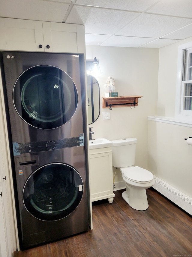 352 Knob Hill Dr, Hamden, CT 06518 - bathroom featuring stacked washing machine and dryer, vanity, wood finished floors, a drop ceiling, and baseboard heating