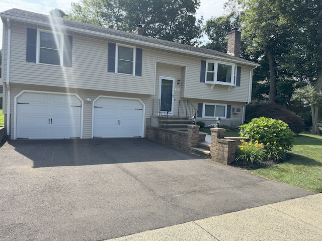 352 Knob Hill Dr, Hamden, CT 06518 - split foyer home featuring a chimney, a garage, and asphalt driveway