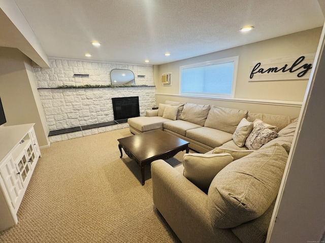 352 Knob Hill Dr, Hamden, CT 06518 - living room with light colored carpet, a wall mounted air conditioner, a stone fireplace, recessed lighting, and a textured ceiling
