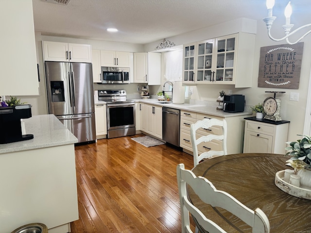 352 Knob Hill Dr, Hamden, CT 06518 - kitchen with stainless steel appliances, glass insert cabinets, hardwood / wood-style floors, and white cabinets