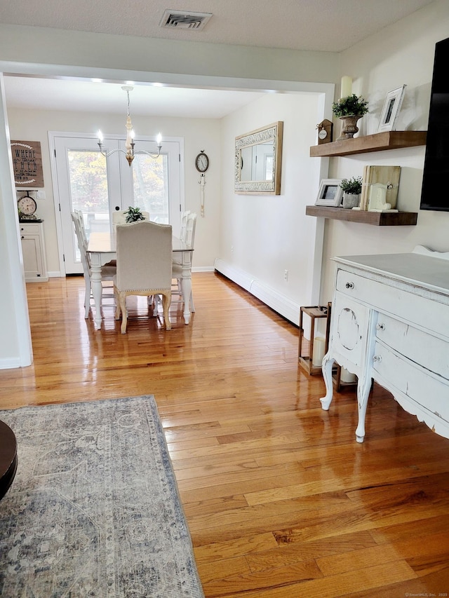 352 Knob Hill Dr, Hamden, CT 06518 - dining room with light wood finished floors, a chandelier, and a baseboard radiator
