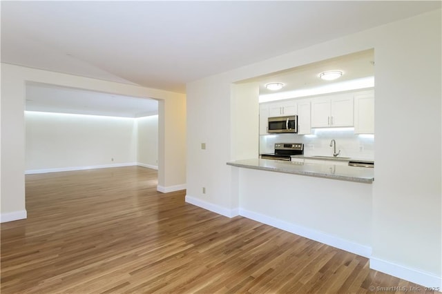 95 Audubon St Unit 339, New Haven, CT 06510 - kitchen featuring stainless steel appliances, light wood finished floors, white cabinets, and tasteful backsplash