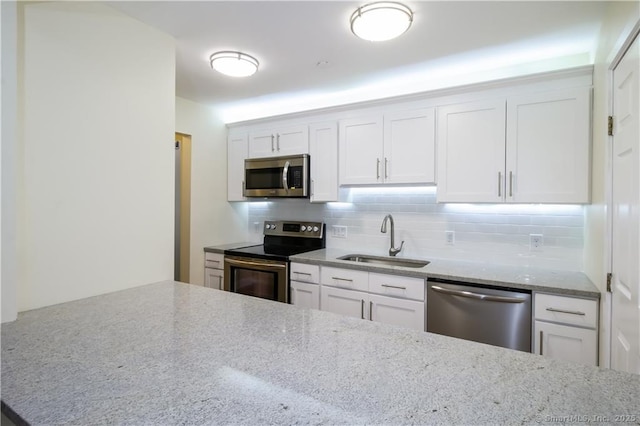 95 Audubon St Unit 339, New Haven, CT 06510 - kitchen with appliances with stainless steel finishes, decorative backsplash, light stone countertops, and white cabinets